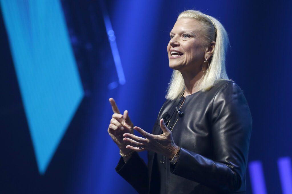 Ginni Rometty mit schwarzer Lederjacke von der Seite fotografiert hält beide Hände in die Höhe