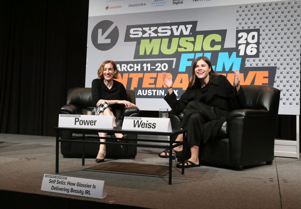 Emily Weiss sitzt auf einem Podium mit einer anderen Frau