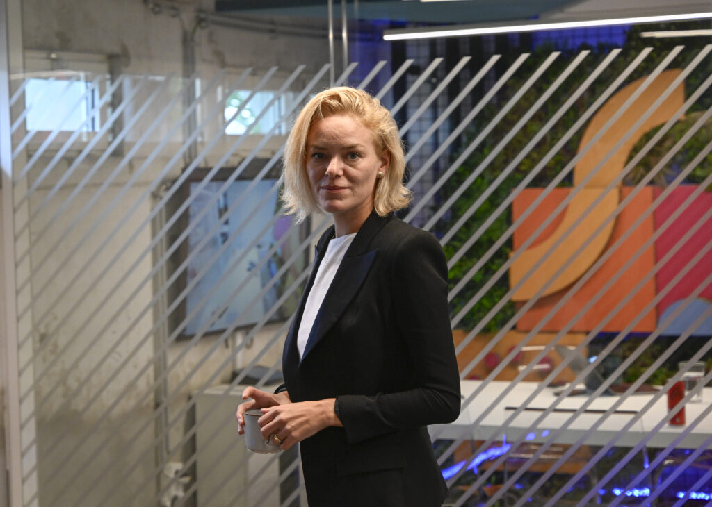Katherina Maher mit schwarzem Sakko hält eine Kaffeetasse