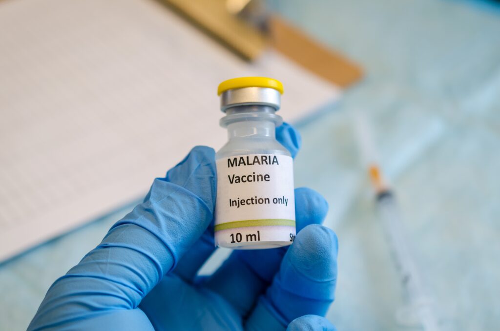 Hand mit blauem Hygienehandschuh hält Malaria Vaccine