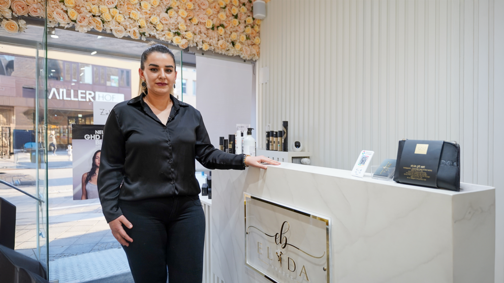 Frau steht im Friseurgesschäft
