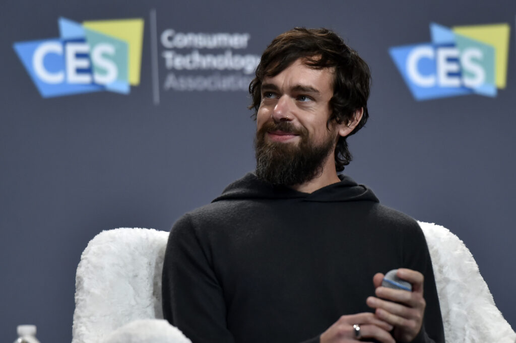 Jack Dorsey mit schwarzem Pullover auf einem weißen Sessel